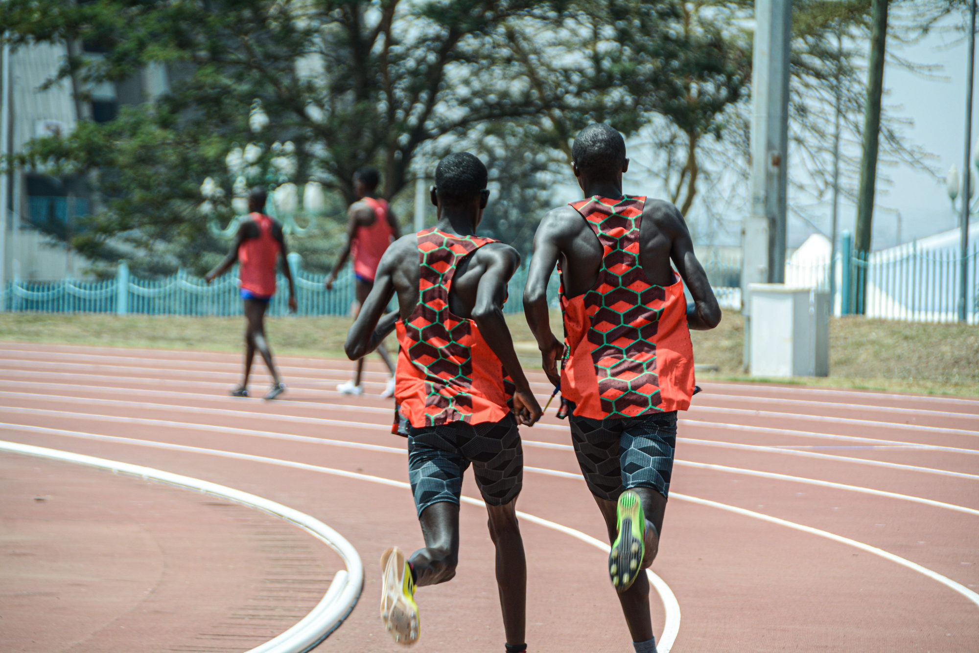 Two athletes running on an outdoor track in Nairobi