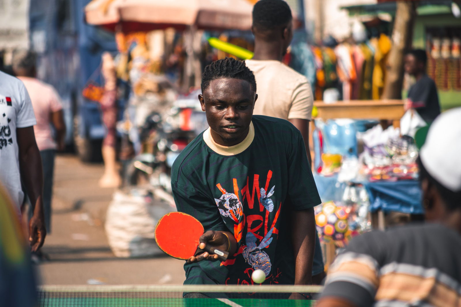 Two players competing in an outdoor table tennis match